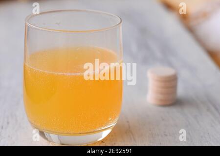 Vitamine, minerali e concetto di supplemento / compressa effervescente su sfondo bianco e arancione effervescente bolle di calcio e vitamina C. Foto Stock