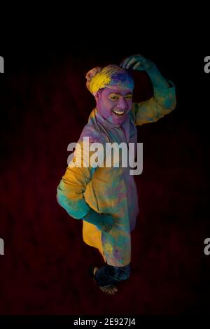 Uomo con gulal sul suo volto danzando in eccitazione su Holi Foto Stock