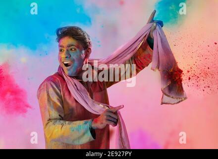 Uomo con gulal sul suo volto danzando in eccitazione su Holi Foto Stock