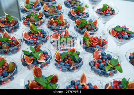 Lamponi, more e mirtilli. In un piatto di vetro ci sono delle bacche meravigliose e deliziose. Cibo sano e sano Foto Stock