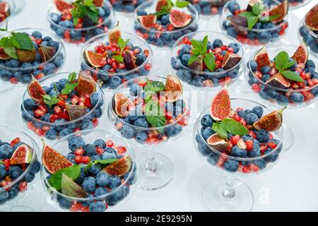 Lamponi, more e mirtilli. In un piatto di vetro ci sono delle bacche meravigliose e deliziose. Cibo sano e sano Foto Stock