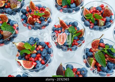 Lamponi, more e mirtilli. In un piatto di vetro ci sono delle bacche meravigliose e deliziose. Cibo sano e sano Foto Stock