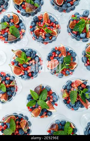 Lamponi, more e mirtilli. In un piatto di vetro ci sono delle bacche meravigliose e deliziose. Cibo sano e sano Foto Stock