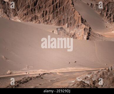 due persone che cavalcano le loro biciclette su una strada sabbiosa Il deserto di Atacama vicino a San Pedro de Atacama in Cile settentrionale Foto Stock