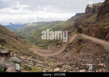 Ripida e tortuosa strada di montagna di sani Pass tra il Sud Africa E il regno del Lesotho controlla il confine sotto il cielo nuvoloso Foto Stock