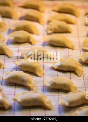 I gnocchi sono fatti a mano. Gnocchi grezzi ripieni di carne in linea nella cucina casalinga Foto Stock