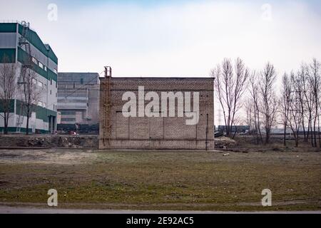 edificio in mattoni in un'area industriale. concetto, nessuna via d'uscita. Un bloccato da finestre in pietra nel muro. Foto Stock