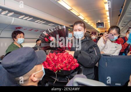 (210202) -- URUMQI, 2 febbraio 2021 (Xinhua) -- Zhang Jianzhi propone alla sua fidanzata Zhao Lolle sul treno D8806 nella regione autonoma di Xinjiang Uygur, 30 gennaio 2021. Zhang Jianzhi, un poliziotto ferroviario di 27 anni che lavora a Urumqi, si fa occupato del suo terzo lavoro di corsa del Festival di primavera. Lavorando per più di 40 giorni consecutivi durante la corsa di viaggio del Festival di Primavera dello scorso anno, Zhang si è sentito dispiaciuto per non essere stato con la sua fidanzata Zhao Lelin. Quest'anno, infine, ha proposto alla sua ragazza sul suo noto treno D8806. "Ho programmato questa proposta speciale sul treno per sorprenderla, un Foto Stock