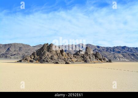 La tribuna sul Racetrack Playa nel Parco Nazionale della Valle della morte, una roccia grigia molto scura circondata da sedimenti argillosi e leggeri Foto Stock