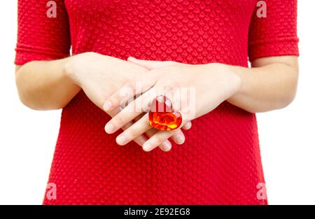 Donna in un vestito rosso mostra un anello con un enorme gemma di plastica color rubino a forma di cuore Foto Stock