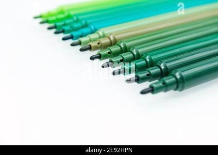 Set di pennarelli verdi su sfondo isolato. Diverse sfumature di verde. Messa a fuoco selettiva. Poster con spazio per la copia Foto Stock
