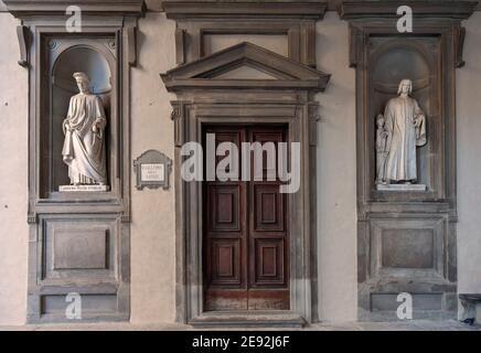 Firenze, Italia - 2020 gennaio 18: Antica porta d'ingresso in legno al Museo della Galleria degli Uffizi. Statue di marmo di Cosimo e Lorenzo Medici su entrambi i lati. Foto Stock