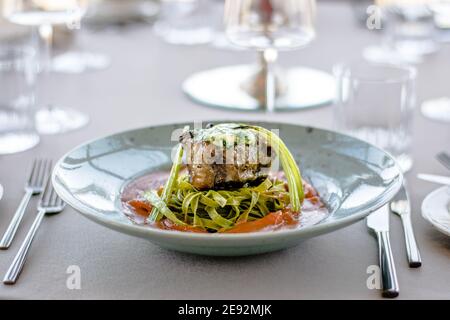 Bistecca di bue alla griglia e fiammato con tagliatelle di erbe verdi una purea di pomodoro in un ristorante Foto Stock