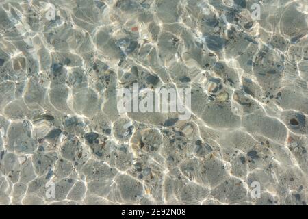 La superficie dell'acqua è così chiara che si può vedere attraverso e vedere le rocce sotto. Foto Stock