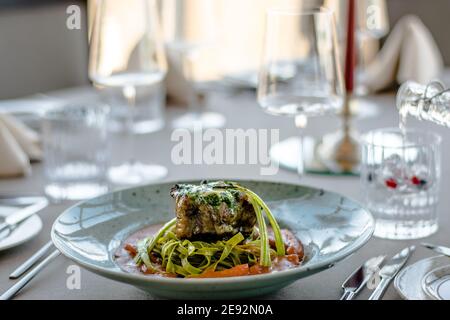 Bistecca di bue alla griglia e fiammato con tagliatelle di erbe verdi una purea di pomodoro in un ristorante Foto Stock