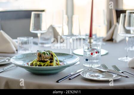 Bistecca di bue alla griglia e fiammato con tagliatelle di erbe verdi una purea di pomodoro in un ristorante Foto Stock