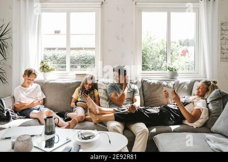 La famiglia felice seduto sul divano nel soggiorno Foto Stock