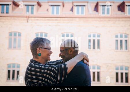 Una coppia sorridente che si abbraccia l'una con l'altra nel balcone Foto Stock