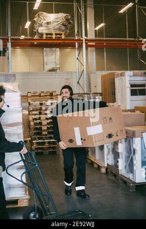 Contenitore per scatole da trasporto per imprenditore di sesso maschile presso il magazzino di distribuzione Foto Stock