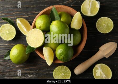 Ciotola con lime matura su fondo in legno, vista dall'alto Foto Stock