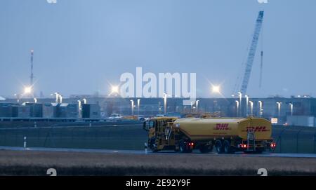 Sassonia, Schkeuditz, 02 febbraio 2021: Un camion cisterna con il logo DHL attraversa i terreni dell'aeroporto di Lipsia/Halle. L'aeroporto continua a diventare uno dei più importanti centri di trasporto aereo in Europa. Anche se il numero dei passeggeri è diminuito, soprattutto a causa della pandemia di Corona, la portata del carico è aumentata in modo significativo: Nel 2020, è aumentata del 11.7%, raggiungendo appena meno di 1.4 milioni di tonnellate. Solo a dicembre, il trasporto aereo è aumentato del 35%. Credit: dpa Picture Alliance/Alamy Live News Foto Stock