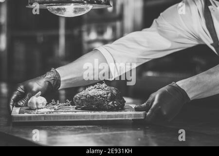 Chef che propone costolette grigliate su un bancone in un ristorante Foto Stock