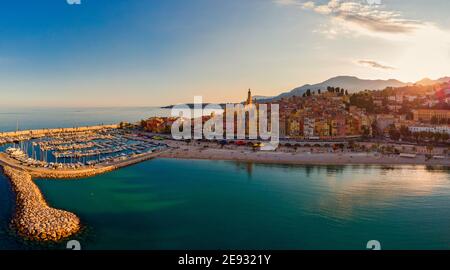 Spiaggia di sabbia sotto il colorato centro storico di Menton sulla Costa Azzurra, Francia. Drone vista aerea su Menton Francia Europa Foto Stock