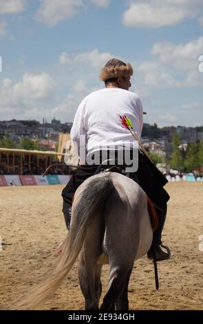 Equitazione con archer in abiti etnici a cavallo Foto Stock