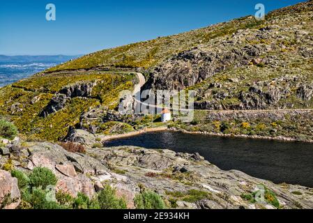 Diga e bacino di Covao do Corral, roccia di granito esposta da erosione glaciale, Parco Naturale Serra da Estrela, Regione Centro, Portogallo Foto Stock