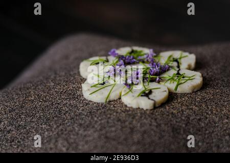 Involtini di pesce su un interessante piatto decorato con aghi di abete in un ristorante Foto Stock