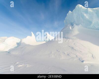 Iceberg congelato nel ghiaccio marino della Baia di Melville, parte della Baia di Baffin, vicino a Kullorsuaq, nell'estremo nord della Groenlandia occidentale. Foto Stock