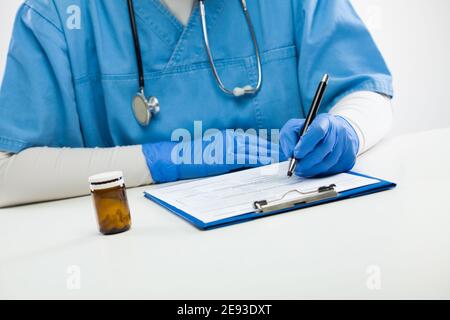 Medico di donna di GP che compila il modulo del paziente durante la visita, l'appuntamento medico in clinica o in ospedale, il professionista sanitario che prescrive la terapia di trattamento, Foto Stock