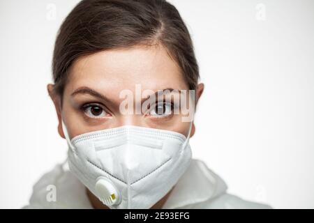 Operatrice medica caucasica femminile che indossa la maschera facciale DPI N95 e. Tuta protettiva, ritratto closeup, prima linea medico chirurgo soccorritore, auto intensiva Foto Stock