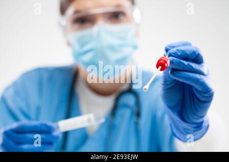 COVID-19 virus Disease Swab Test Sample kit,operatrice di frontline medica femminile che tiene la gola o il naso bastone di swabbing,apparecchiatura per la raccolta di campioni virali, Foto Stock