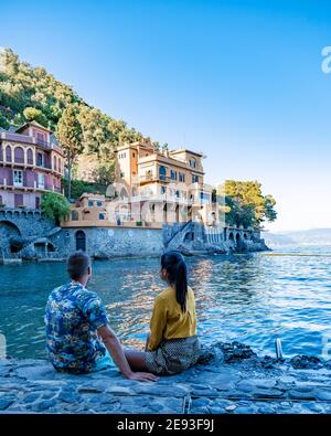 Bella costa con case colorate a Portofino, Italia Europa Portofino in Liguria, Italia. Genova coppia uomo e donna di mezza età in visita in Italia durante le vacanze Foto Stock