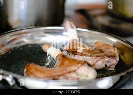 Chef che prepara la quaglia in una padella in un ristorante Foto Stock