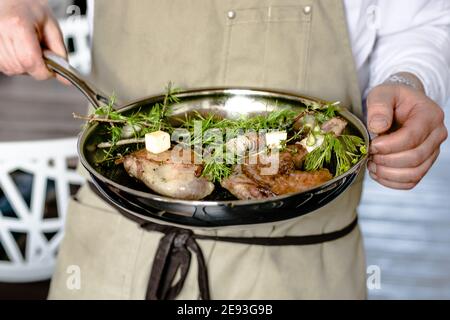 Chef che prepara la quaglia in una padella in un ristorante Foto Stock