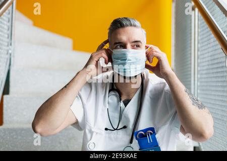 Medico che indossa la maschera facciale Foto Stock
