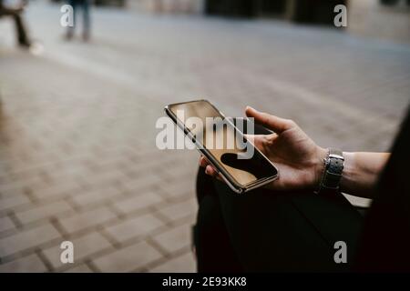 Mano tagliata di donna d'affari che usa lo smartphone Foto Stock