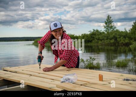Donna sorridente che fa carpenteria Foto Stock