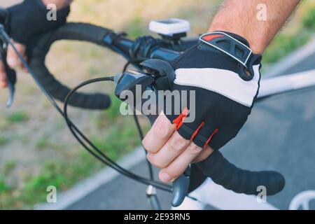 Mani in guanti sul manubrio della bicicletta Foto Stock