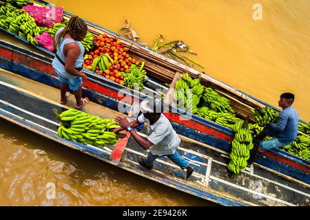 I lavoratori afro-colombiani scaricano mazzi di banane dalle navi da carico sul mercato del fiume Atrato a Quibdó, Chocó, nella regione del Pacifico della Colombia. Foto Stock