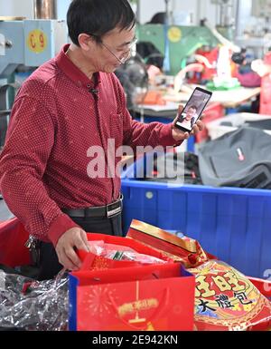 (210202) -- FUZHOU, 2 febbraio 2021 (Xinhua) -- Zhang Liangguo ha una video chat con suo figlio a Wellgreen Outdoor Co., Ltd. Nella contea di Minhou, Fuzhou, nella provincia del Fujian della Cina sudorientale, 1 febbraio 2021. A seguito della rinascita di sporadici casi COVID-19, molti luoghi in tutta la Cina hanno incoraggiato i residenti e i lavoratori migranti a rimanere messi per celebrare il Festival di primavera, per ridurre il flusso di personale e frenare la diffusione del coronavirus durante il periodo di vacanza. Nella contea di Minhou, Fuzhou, nella provincia di Fujian, una fabbrica di attrezzi all'aperto ha dato i kit regalo di Capodanno a più di 90 lavoratori che hanno dicembre Foto Stock