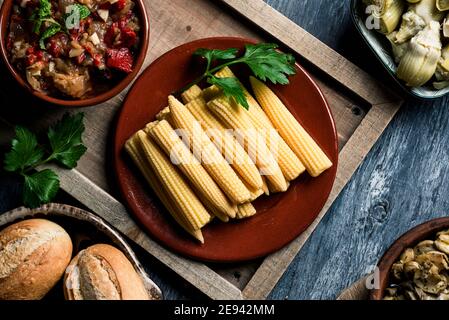 vista ad alto angolo di alcuni cornetti cotti in un piatto su un tavolo accanto ad una ciotola con qualche escalivada spagnola, fatta con verdure arrostite diverse, s Foto Stock