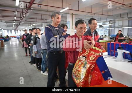 (210202) -- FUZHOU, 2 febbraio 2021 (Xinhua) -- Zhang Liangguo (fronte) coda per ottenere i kit del festival a Wellgreen Outdoor Co., Ltd. Nella contea di Minhou, Fuzhou, nella provincia del Fujian della Cina sudorientale, 1 febbraio 2021. A seguito della rinascita di sporadici casi COVID-19, molti luoghi in tutta la Cina hanno incoraggiato i residenti e i lavoratori migranti a rimanere messi per celebrare il Festival di primavera, per ridurre il flusso di personale e frenare la diffusione del coronavirus durante il periodo di vacanza. Nella contea di Minhou, Fuzhou, nella provincia di Fujian, una fabbrica di attrezzi all'aperto ha dato i kit regalo di Capodanno a più di 90 lavoratori che haven Foto Stock