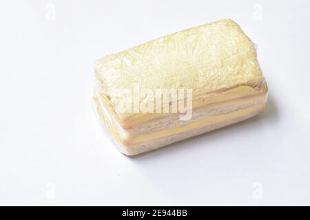 sandwich farcito prosciutto e formaggio confezionamento in plastica trasparente su sfondo bianco Foto Stock