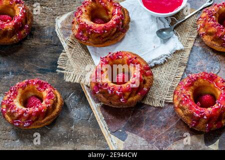 Mini torte alla vaniglia con glassa di lamponi - angolo alto visualizza Foto Stock