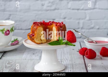 Mini torta alla vaniglia con glassa di lamponi Foto Stock