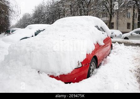 Auto sotto coperta spessa di neve dopo tempesta. Veicoli interrati sotto ghiaccio. Nessuno Foto Stock