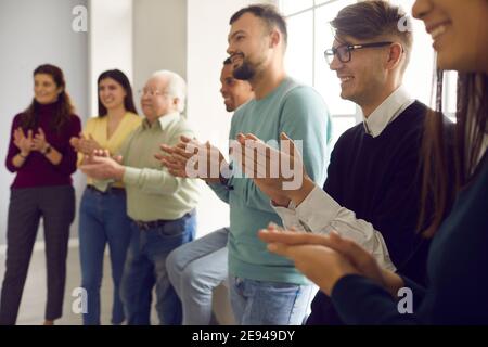 Gruppo di persone sorridenti applaudendo, ringraziando l'oratore per l'interessante presentazione Foto Stock